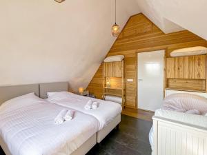 2 camas en un dormitorio ático con paredes de madera en Beautiful holiday home in Kropswolde with private terrace, en Kropswolde
