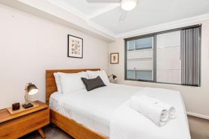 Un dormitorio con una gran cama blanca y una ventana en 2 Royal Rest Quality 2br West Perth-parking en Perth