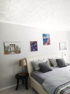 um quarto com uma cama e algumas fotografias na parede em Apartment with garden Hanja em Mostar