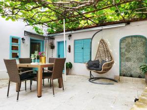 um pátio com uma mesa, cadeiras e um baloiço em Apartment with garden Hanja em Mostar