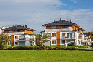een groep grote huizen in een grasveld bij Käptn Brass Villa 5 App 3 Strandrose in Dierhagen