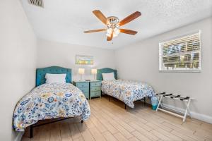1 Schlafzimmer mit 2 Betten und einem Deckenventilator in der Unterkunft Holmes Beach Bungalow - B in Holmes Beach