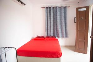 1 dormitorio con cama roja y ventana en CHALET MERAH MERIAM, YAN KEDAH, en Yan