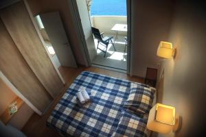 a bedroom with a bed with a blue and white checkered blanket at L'ODYSSÉE BLEUE VUE MER in Cassis