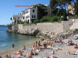 a group of people on a beach near the water at L'ODYSSÉE BLEUE VUE MER in Cassis