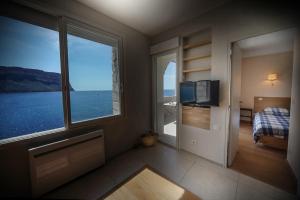 a bedroom with a view of the ocean from a window at L'ODYSSÉE BLEUE VUE MER in Cassis