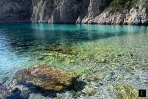 a large body of water with rocks and algae at L'ODYSSÉE BLEUE VUE MER in Cassis