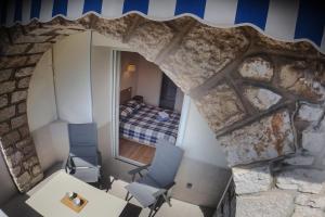 a room with a stone wall and two chairs and a bed at L'ODYSSÉE BLEUE VUE MER in Cassis