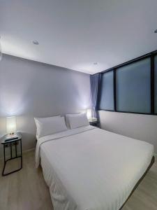 a bedroom with a large white bed and a window at W 21 Hotel Bangkok in Bangkok