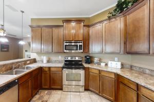 una cocina con armarios de madera y electrodomésticos de acero inoxidable en The Yellow Hibiscus en Jacksonville