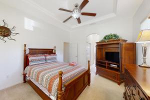 1 dormitorio con 1 cama y TV de pantalla plana en The Yellow Hibiscus en Jacksonville