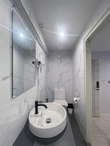a white bathroom with a sink and a toilet at W 21 Hotel Bangkok in Bangkok