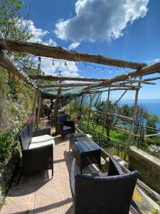 patio ze stołem i krzesłami oraz oceanem w obiekcie Casa Barbara w Amalfi