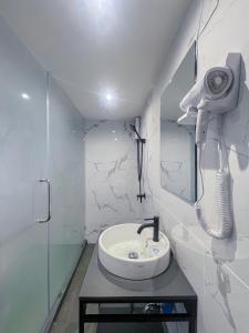 ein weißes Bad mit einem Waschbecken und einer Dusche in der Unterkunft W 21 Hotel Bangkok in Bangkok