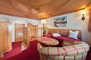 a living room with a couch and a table at Eggerwirt Kitzbühel, Hotel & Restaurant in Kitzbühel