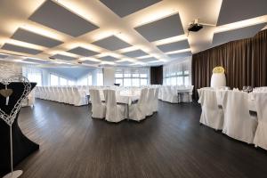 a banquet hall with white tables and white chairs at Hotel Restaurant Zehn-Brunnen in Renningen