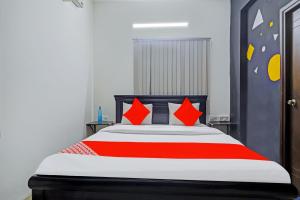 a bedroom with a large bed with red pillows at OYO Rs Hotel Near Hitech City in Kondapur