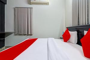 a bedroom with a white bed with red pillows at OYO Rs Hotel Near Hitech City in Kondapur
