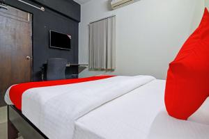 a bedroom with a large bed with a red pillow at OYO Rs Hotel Near Hitech City in Kondapur