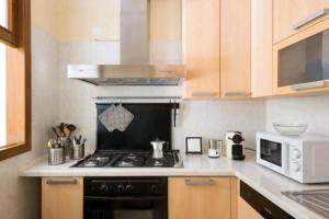 a kitchen with a stove and a microwave at Casa Bastione Taormina in Taormina