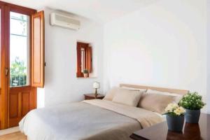 a white bedroom with a bed and a window at Casa Bastione Taormina in Taormina