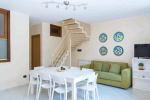 a living room with a white table and a green couch at Casa Bastione Taormina in Taormina