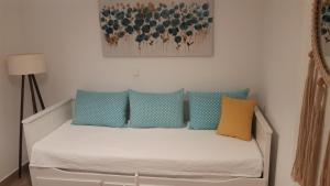 sypialnia z łóżkiem z niebieskimi i żółtymi poduszkami w obiekcie Apartment Tina w Trogirze