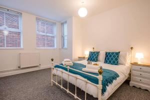 a bedroom with a bed with blue and white pillows at 1 Abbey Mews in Leiston