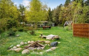 a backyard with a fire pit in the grass at Stunning Home In Thyholm With Kitchen in Thyholm
