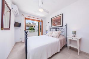 een slaapkamer met een bed en een raam bij Casa Ginebro in Font de Sa Cala