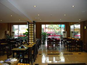 a restaurant with wooden tables and chairs and windows at Lux Riverside Hotel & Apartment in Phnom Penh