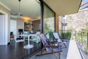 a patio with chairs and a table on a balcony at La TORRETTA Studios & Suite in Lesa
