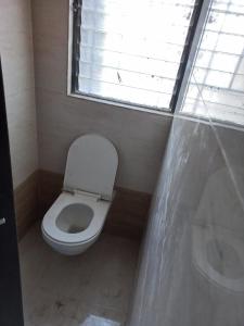 een kleine badkamer met een toilet en een raam bij The Nest - Luxurious Landing in Sāngli
