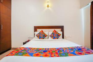 a bedroom with a large bed with a colorful comforter at FabHotel Home Tree Service Apartment - Nr Anna Tower in Chennai