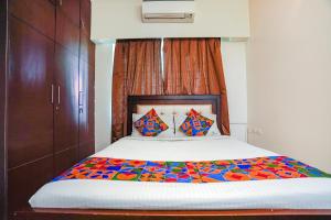 a bedroom with a large bed with a colorful comforter at FabHotel Home Tree Service Apartment - Nr Anna Tower in Chennai