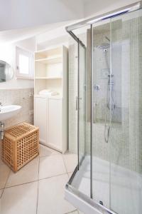 y baño con ducha acristalada y lavamanos. en Villa Luminosa, en Brindisi