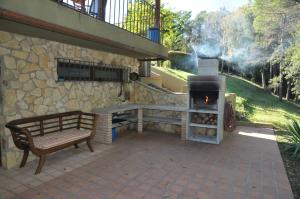 un patio con banco y chimenea en Villa Masia Can Bora, en Bonmatí