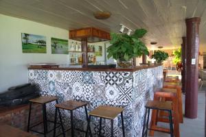 a restaurant with a bar with stools in front of it at Greenfield Ecostay in Phong Nha