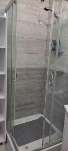 a shower with a glass door in a bathroom at HOSTEL Róża in Suwałki