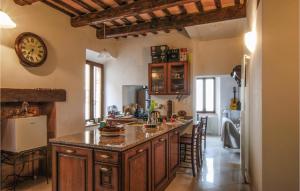 a kitchen with a large island with a clock on the wall at Gorgeous Apartment In Montefortino With Wifi in Montefortino