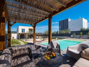 a patio with a table and chairs and a swimming pool at Villa in Bibinje with Private Pool and Garden in Bibinje