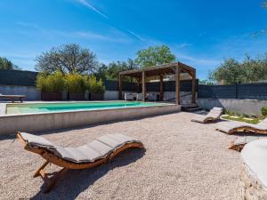 a group of lounge chairs next to a swimming pool at Villa in Bibinje with Private Pool and Garden in Bibinje