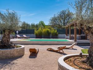 un patio avec deux bancs et une piscine dans l'établissement Villa in Bibinje with Private Pool and Garden, à Bibinje