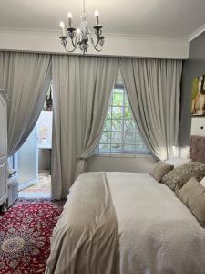 - une chambre avec un grand lit et une fenêtre dans l'établissement Somerset West Garden Apartments 1, à Somerset West