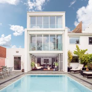 a house with a swimming pool in front of it at Studio for 3 with a private balcony in a Cubic house with outside pool in London