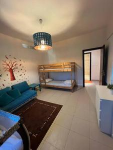 ein Wohnzimmer mit einem blauen Sofa und Etagenbetten in der Unterkunft Apartment at Samarah Dead Sea Resort in Sowayma