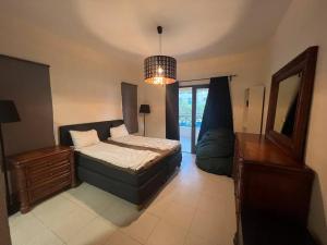 a bedroom with a bed and a dresser and a mirror at Apartment at Samarah Dead Sea Resort in Sowayma