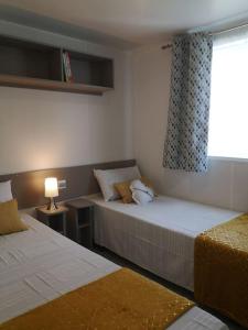 Una habitación de hotel con dos camas y una ventana. en Coquillages & Crustacés avec Piscine Chauffée & Plage, en Marennes