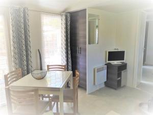 Un comedor con una mesa y un televisor. en Coquillages & Crustacés avec Piscine Chauffée & Plage, en Marennes