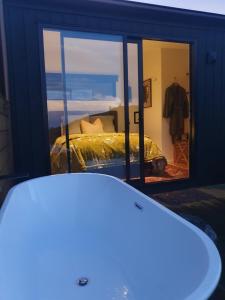 a reflection of a bedroom with a bed in a mirror at Hapuku River Terrace a Eco Tiny House escape in Kaikoura